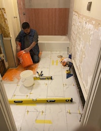 a man is laying tile in a bathroom