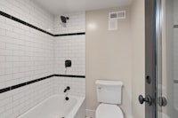 a white and black tiled bathroom with a toilet
