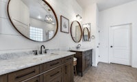 a bathroom with two sinks and two mirrors