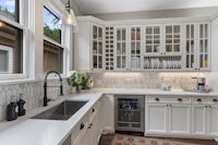 a kitchen with white cabinets and a sink