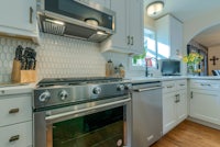a kitchen with stainless steel appliances and white cabinets