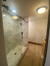a bathroom is being remodeled with a glass shower door