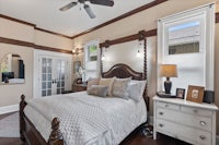 a bedroom with hardwood floors and a ceiling fan