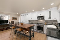a kitchen with white cabinets and stainless steel appliances