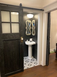 a bathroom with a black door and a sink